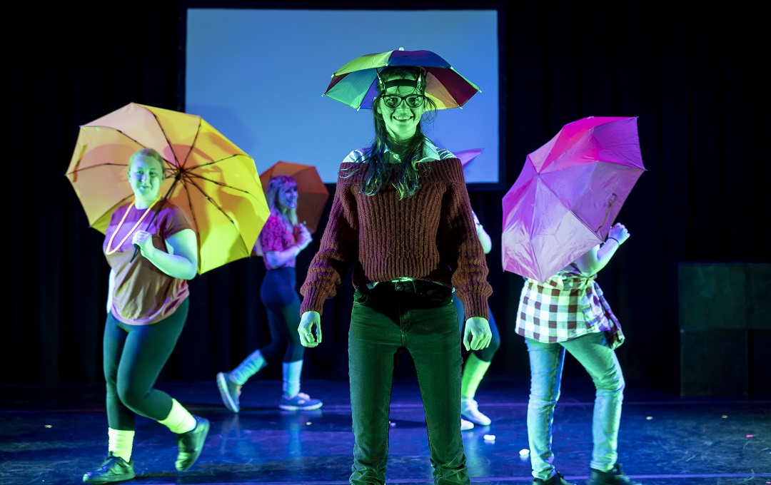 Young people performing lit in green lighting