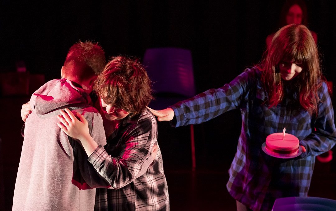 Three young people acting in a play
